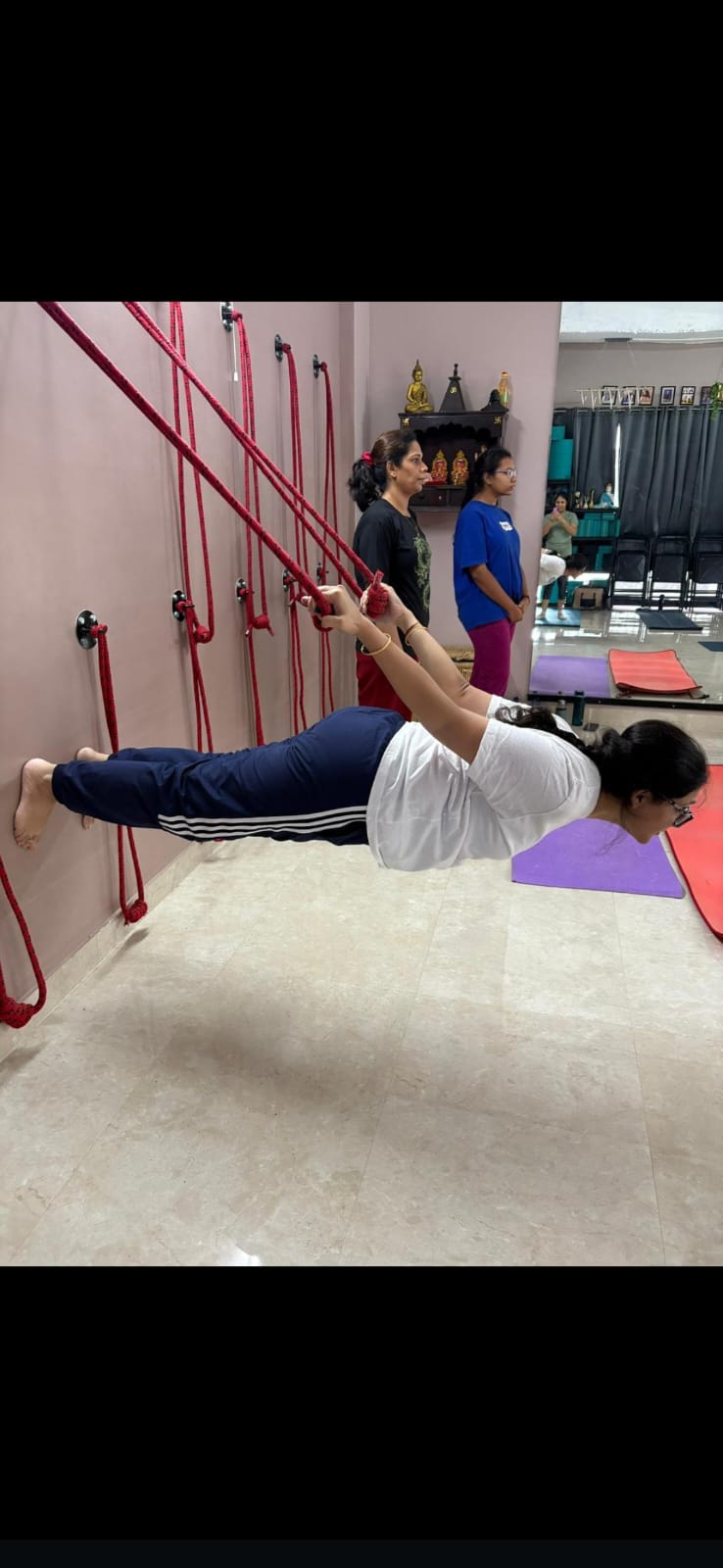 Priyanka performing an advanced wall rope yoga posture at Attmashuddhi